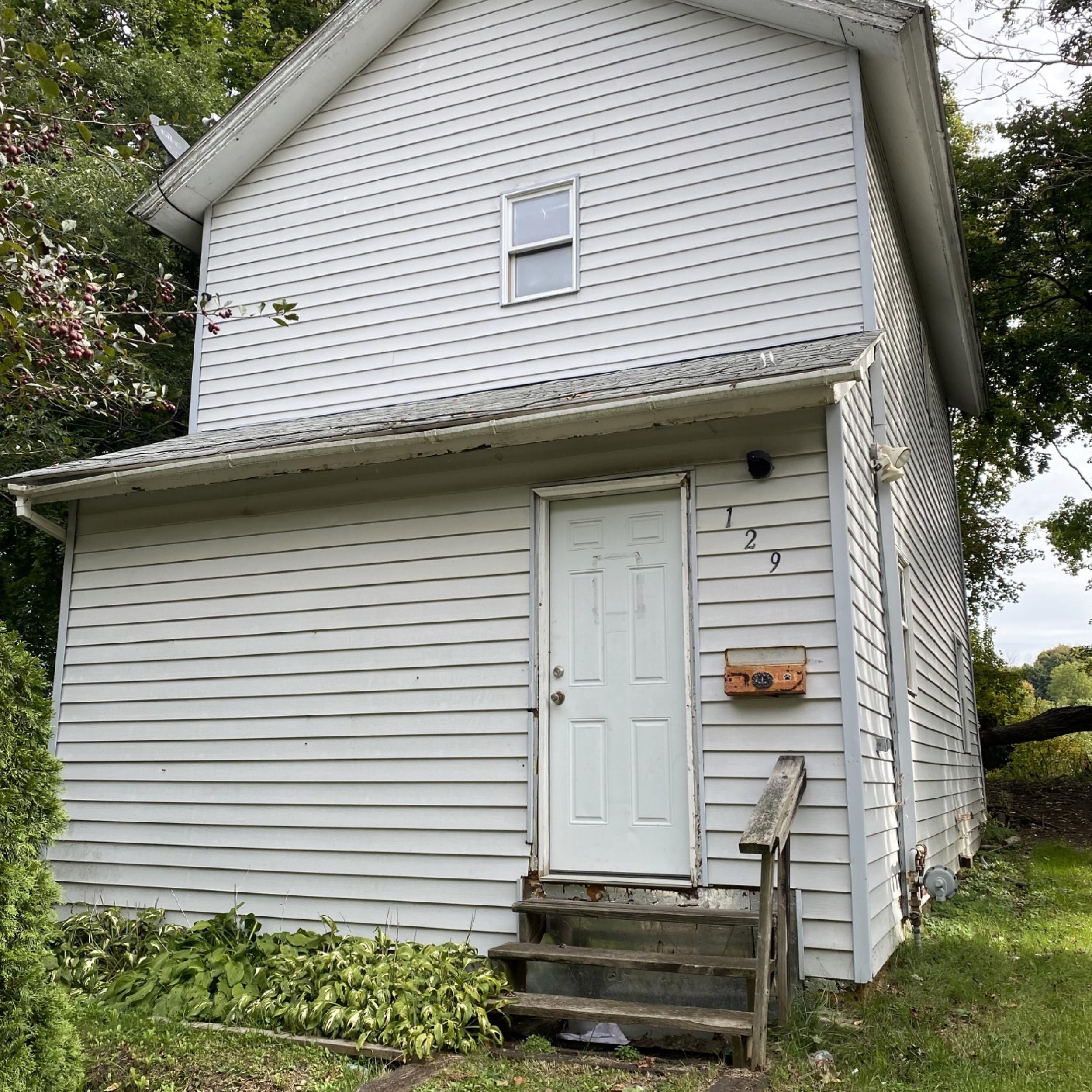 Image of a small house with gray siding